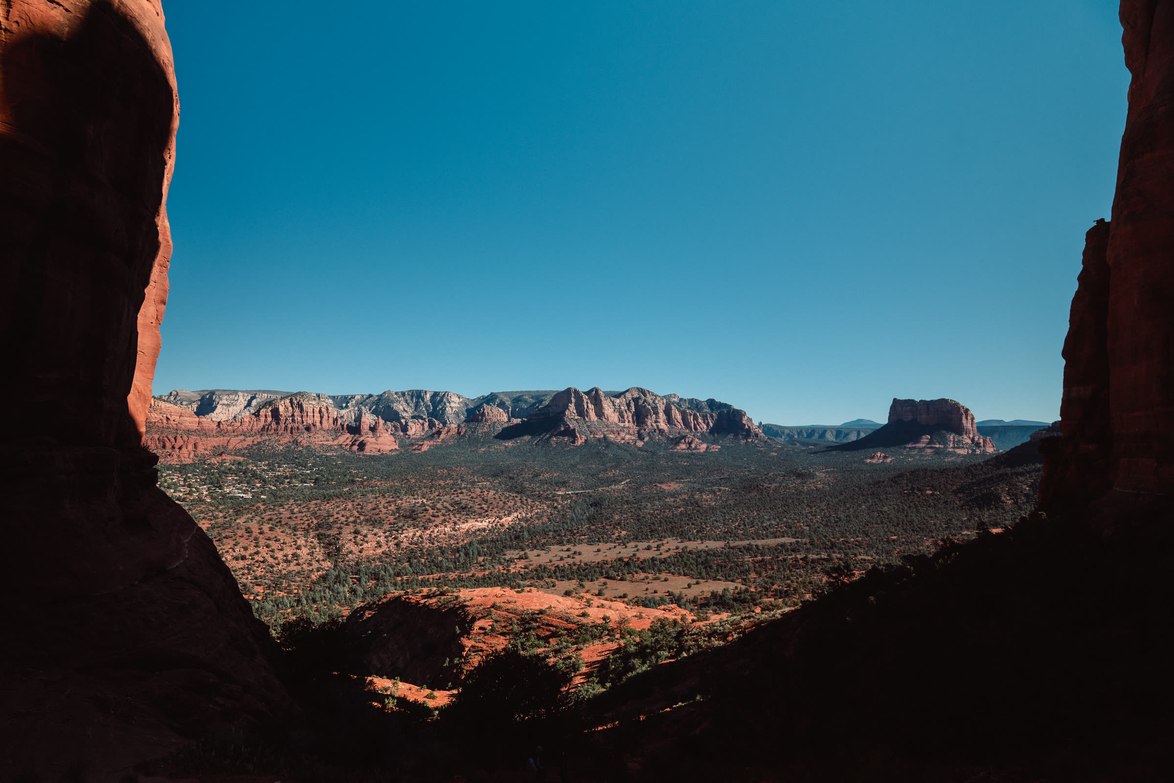 A wide red rock valley framed between two dark rock walls