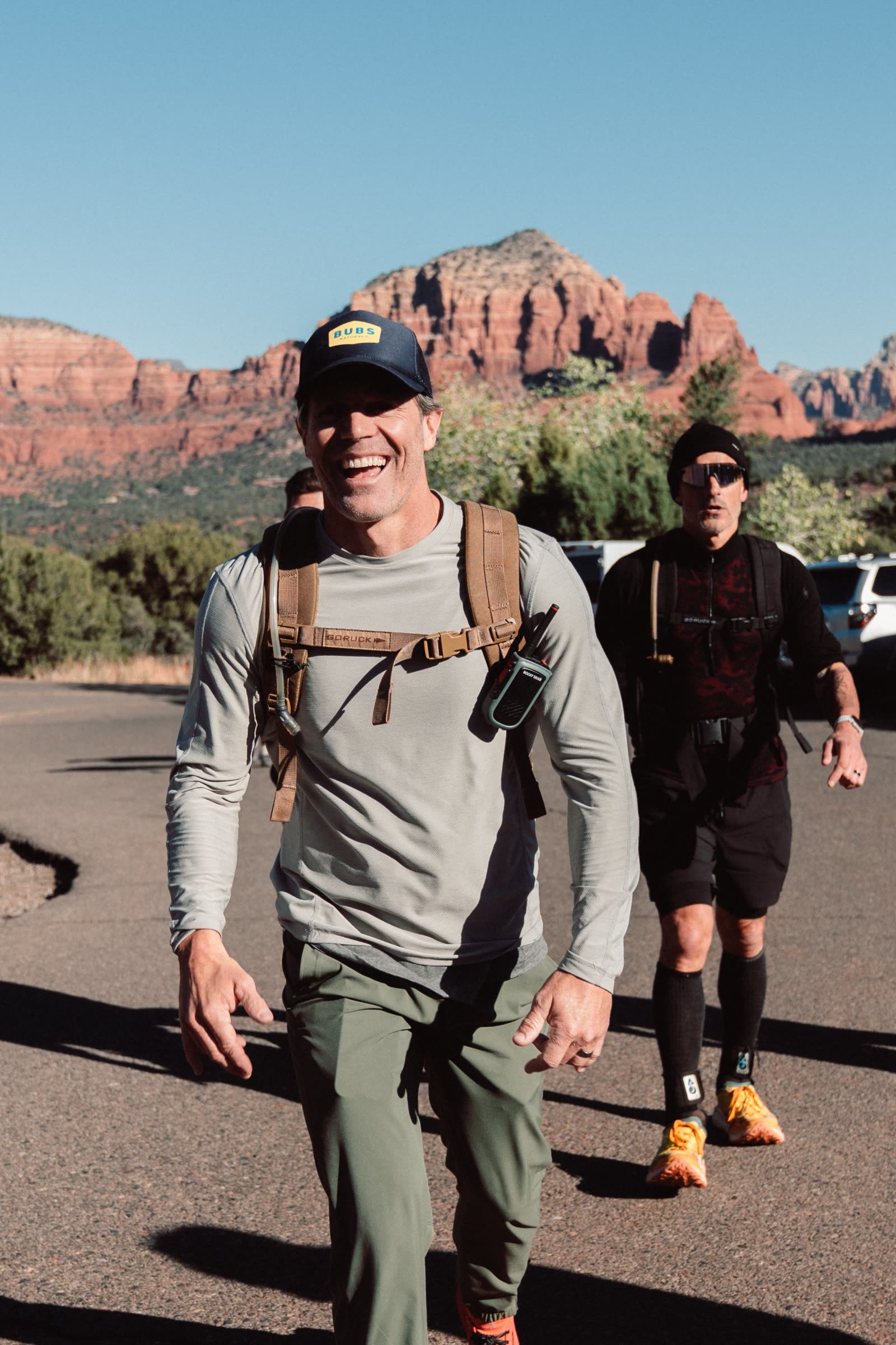 Eric Botsford smiling with a ruck on his back in front of Sedona's red rock